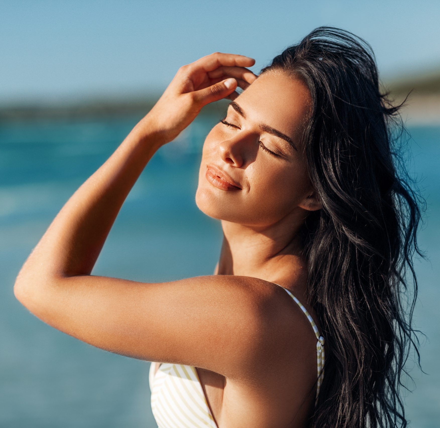 people, summer and swimwear concept - happy smiling young woman in bikini swimsuit on beach