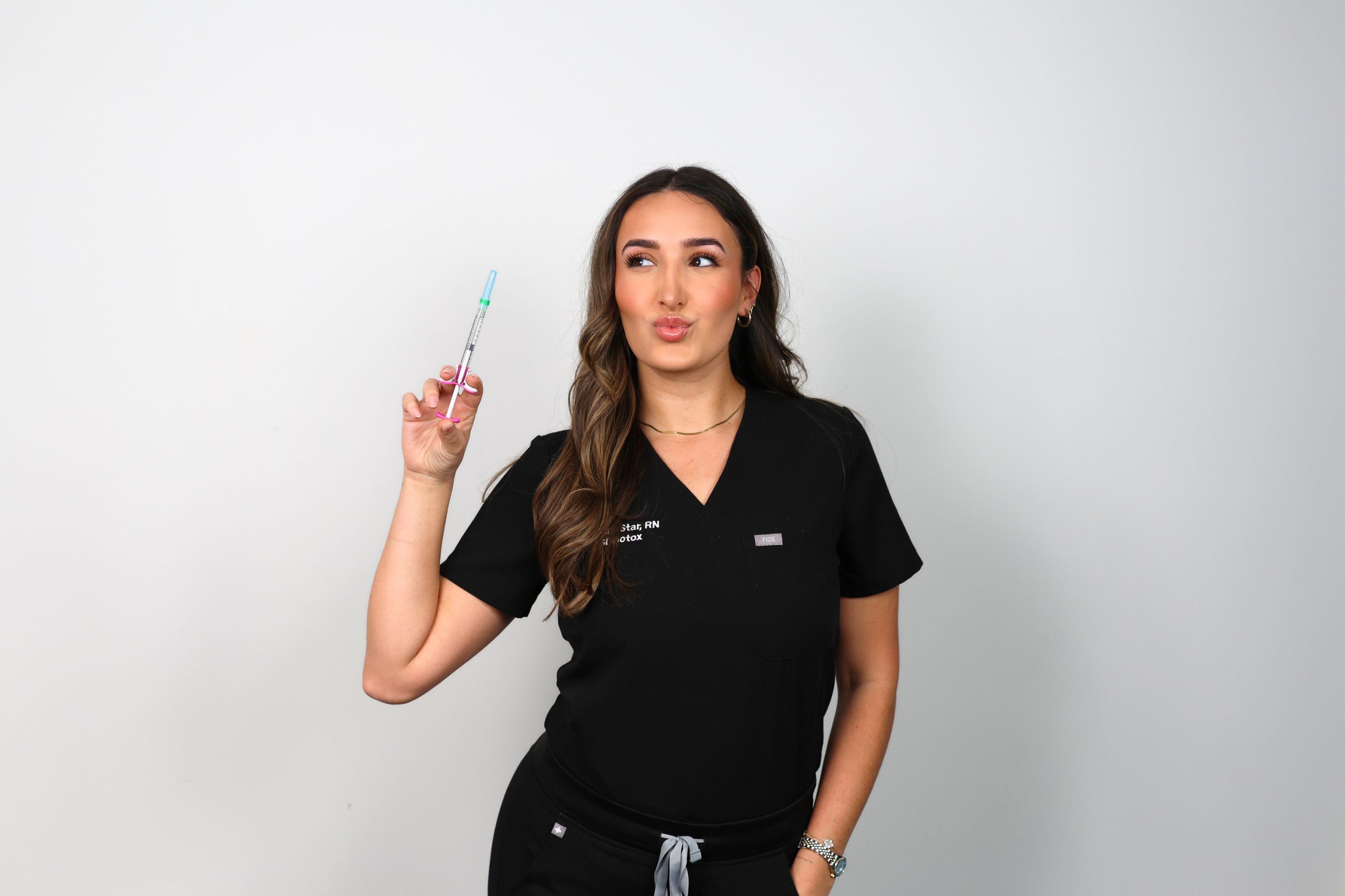 SDBotox San Diego injector holding a lip filler syringe